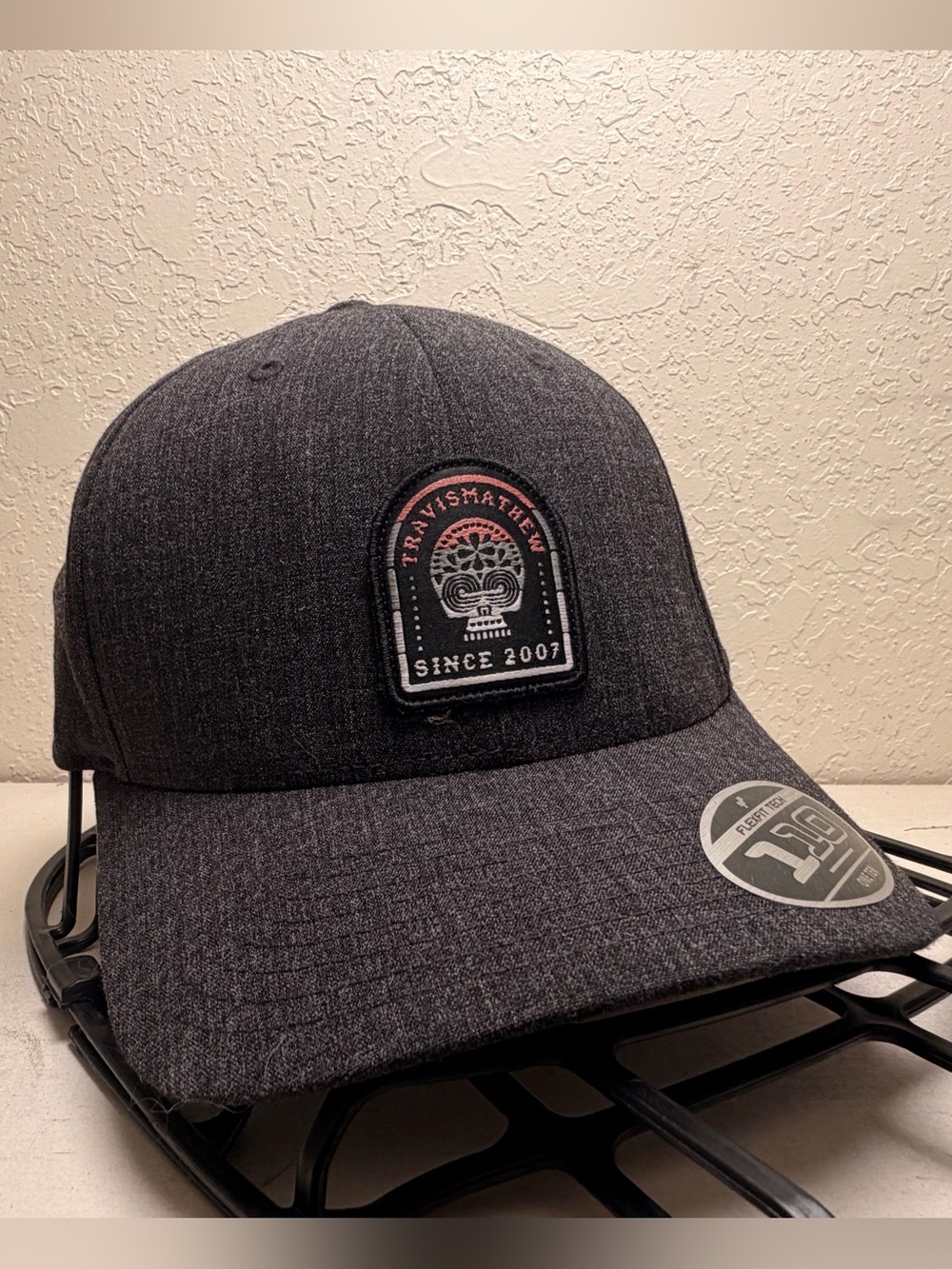 Travis Mathew Dark Gray Patch Baseball Cap with Black and White Logo